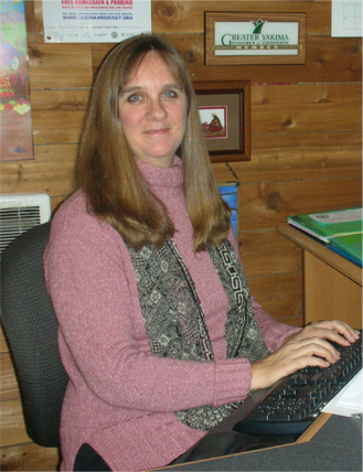 Danielle Surkatty, founder of Yakindo Web Designs sits at a computer desk.